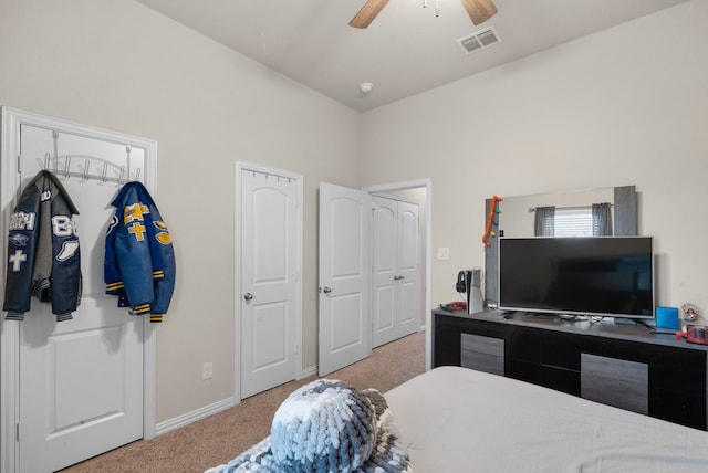 carpeted bedroom featuring two closets and ceiling fan