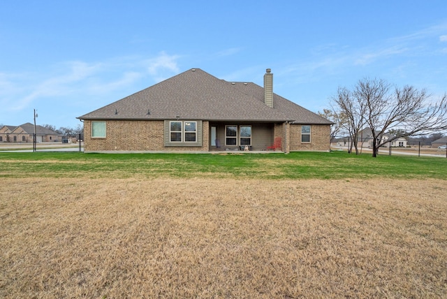 rear view of house with a lawn and a patio area