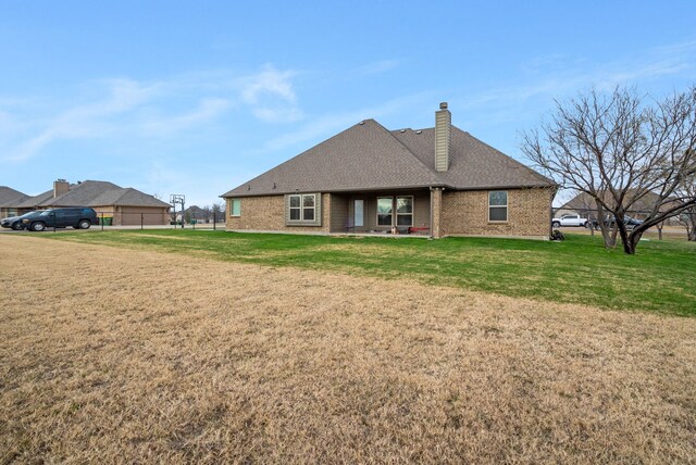 back of house with a patio area and a yard