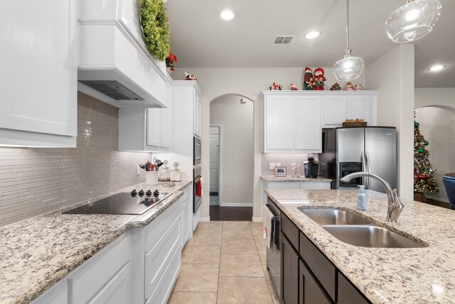 kitchen with sink, white cabinets, custom exhaust hood, and appliances with stainless steel finishes