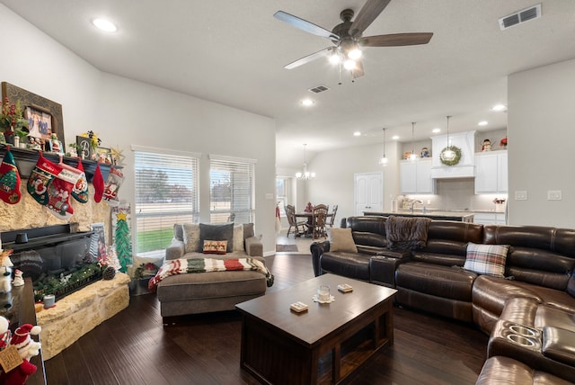 living room featuring dark hardwood / wood-style flooring, ceiling fan with notable chandelier, and sink