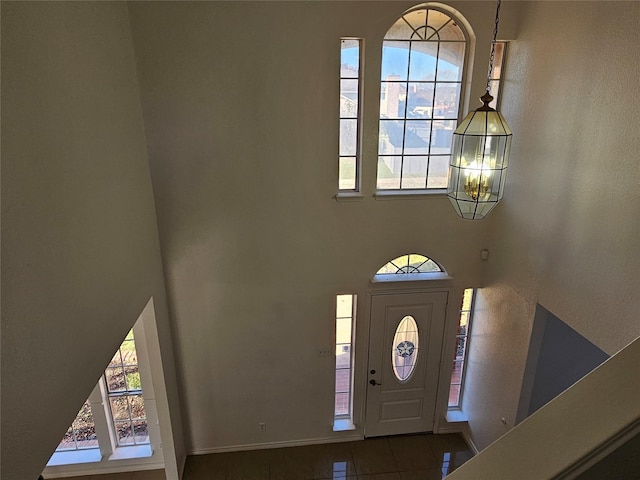 tiled entrance foyer featuring an inviting chandelier