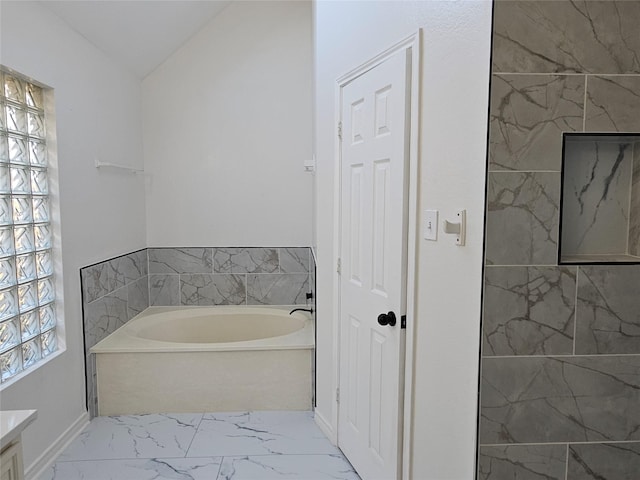 bathroom with a bathing tub, vanity, and lofted ceiling