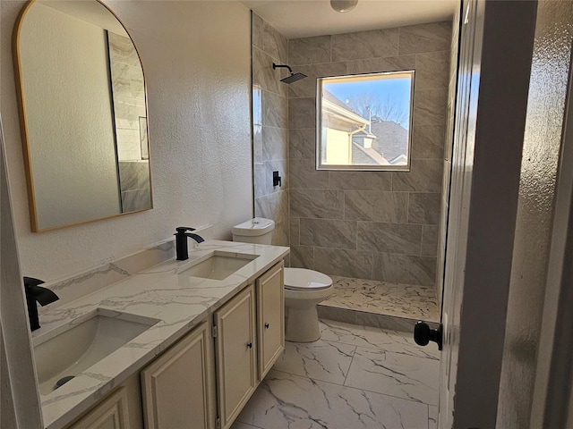 bathroom featuring vanity, toilet, and a tile shower