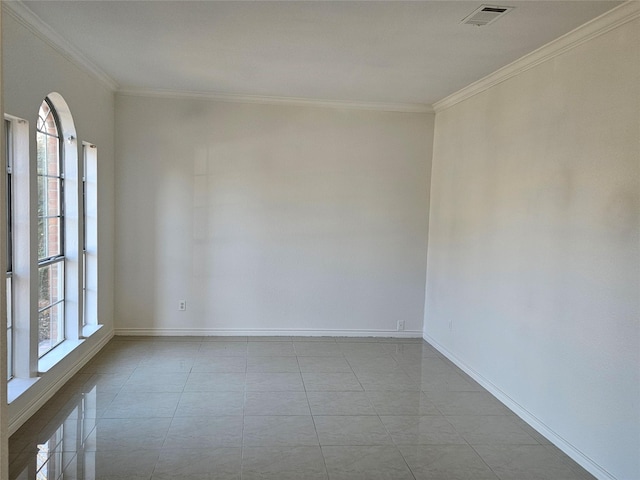 spare room with light tile patterned floors, a wealth of natural light, and crown molding