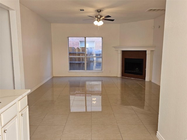 unfurnished living room featuring ceiling fan and light tile patterned floors