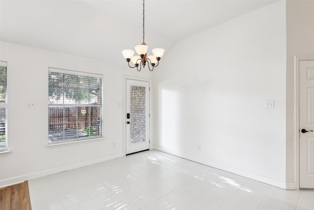 tiled entryway with a chandelier and lofted ceiling