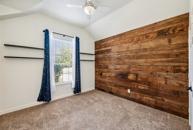 unfurnished room featuring a textured ceiling, ceiling fan, light carpet, and vaulted ceiling