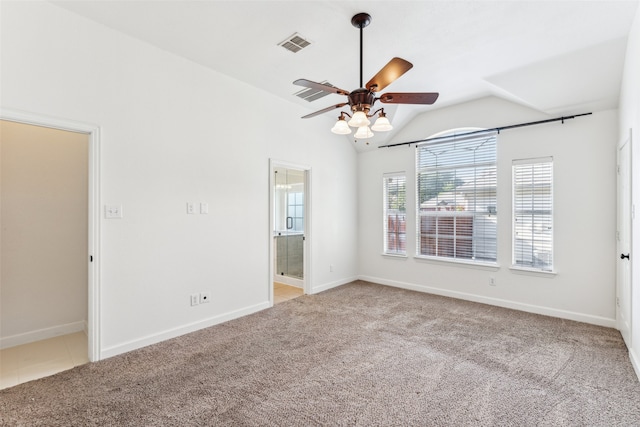 spare room featuring ceiling fan, light colored carpet, and vaulted ceiling