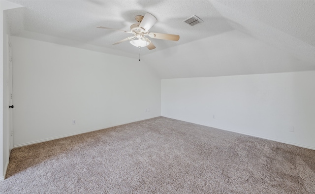 bonus room with lofted ceiling, ceiling fan, carpet floors, and a textured ceiling