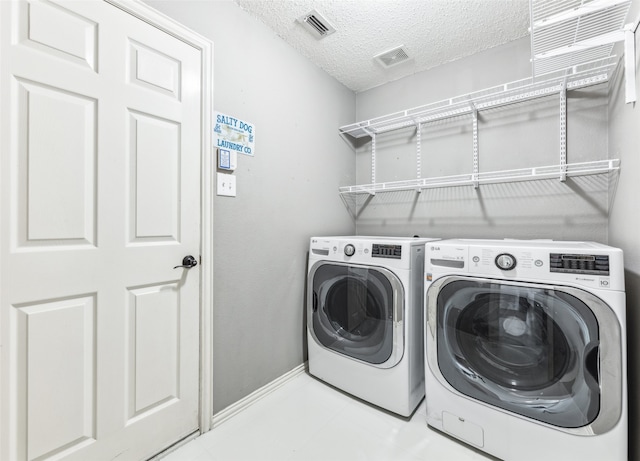 washroom featuring separate washer and dryer and a textured ceiling