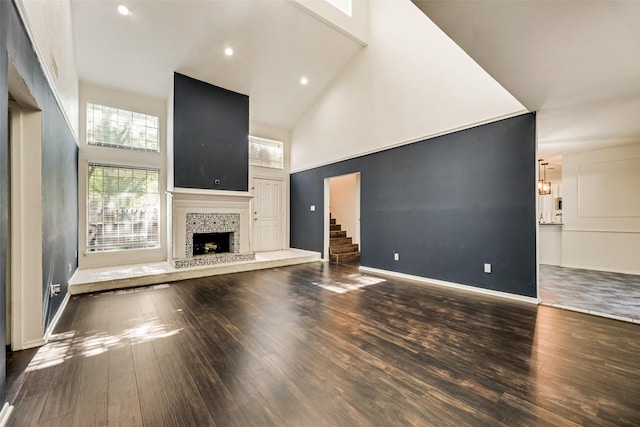 unfurnished living room with a towering ceiling and dark wood-type flooring