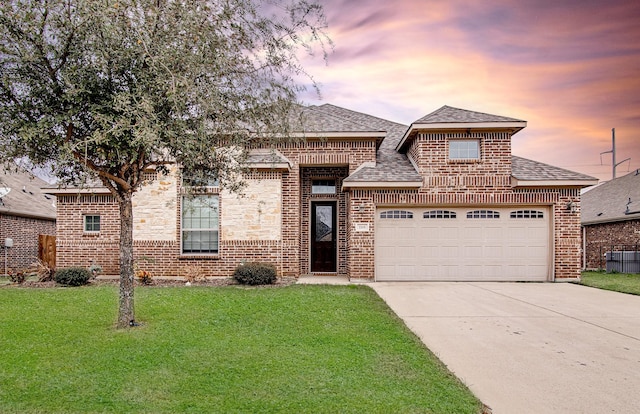 view of front of property with a yard and a garage