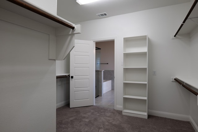 walk in closet featuring dark colored carpet