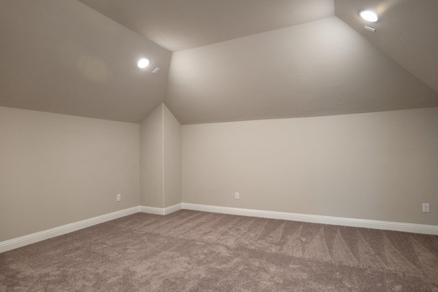 additional living space featuring lofted ceiling and carpet floors