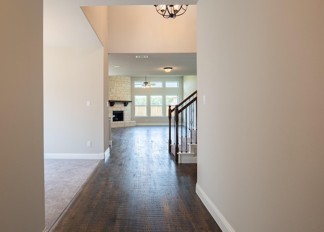 interior space with a notable chandelier, dark carpet, and a high ceiling