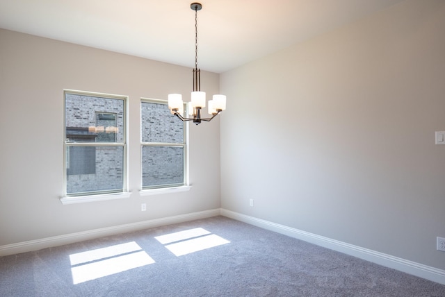 empty room featuring carpet and a chandelier