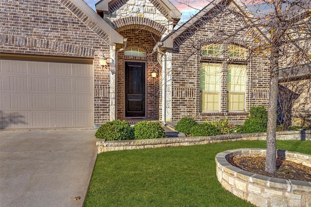 entrance to property with a garage and a yard