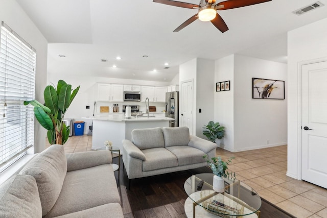 living room featuring light tile patterned floors and ceiling fan