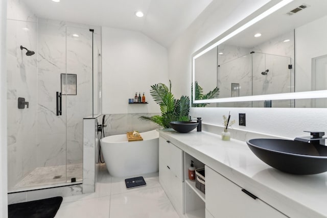 bathroom featuring vanity, independent shower and bath, and lofted ceiling