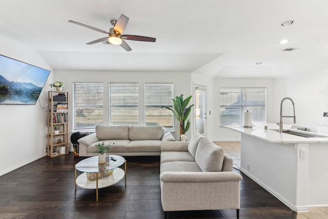 living room featuring ceiling fan, dark hardwood / wood-style flooring, sink, and vaulted ceiling