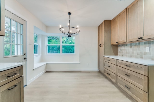 unfurnished dining area featuring a chandelier and light hardwood / wood-style floors