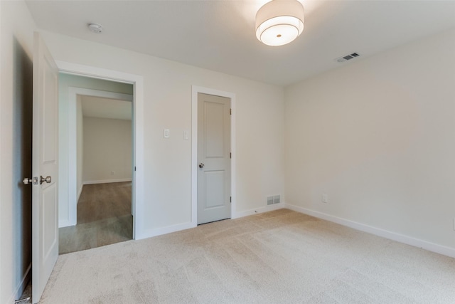 unfurnished bedroom featuring light carpet and a closet