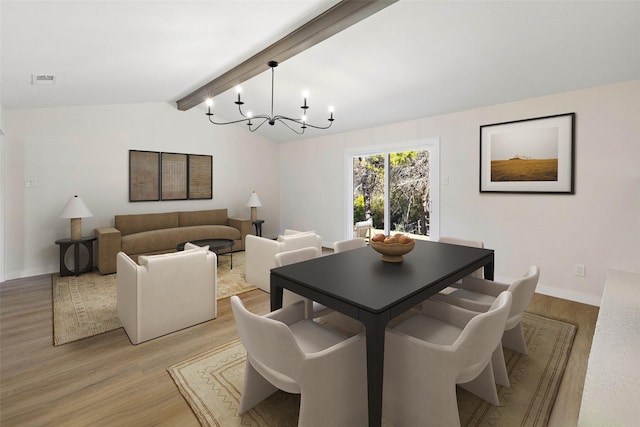 dining space featuring vaulted ceiling with beams, light hardwood / wood-style flooring, and a notable chandelier