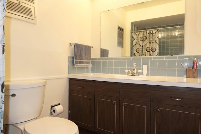 bathroom featuring vanity, backsplash, and toilet