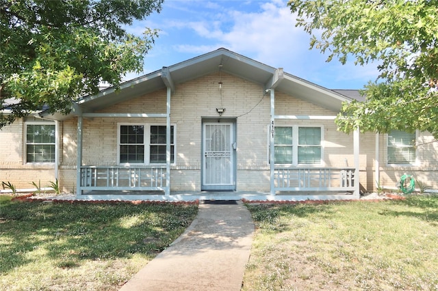 view of front of home featuring covered porch and a front lawn