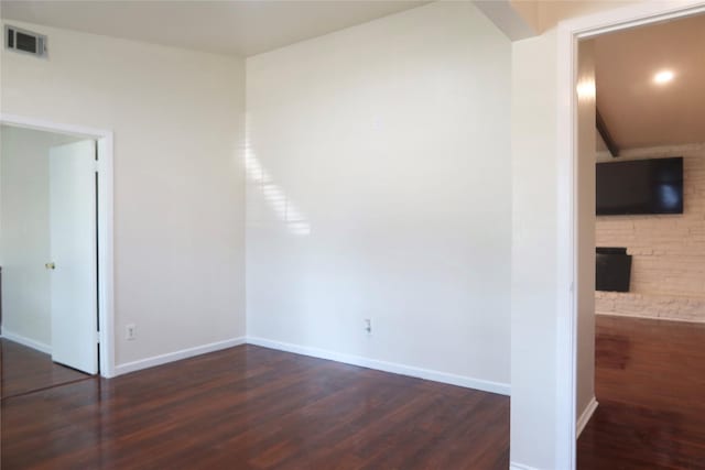 empty room featuring dark hardwood / wood-style flooring and a fireplace