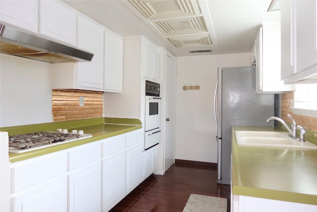 kitchen featuring white appliances, dark wood-type flooring, ventilation hood, white cabinets, and sink