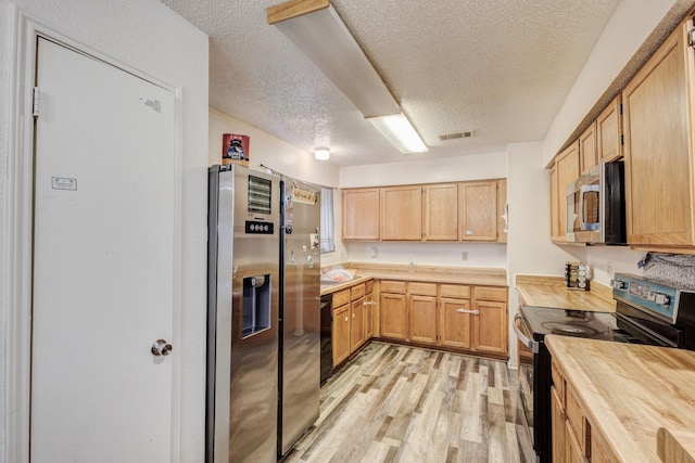 kitchen featuring light wood-type flooring, light brown cabinets, a textured ceiling, and black appliances