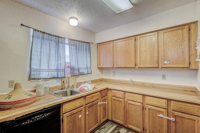 kitchen featuring dishwasher, wood-type flooring, a textured ceiling, and sink