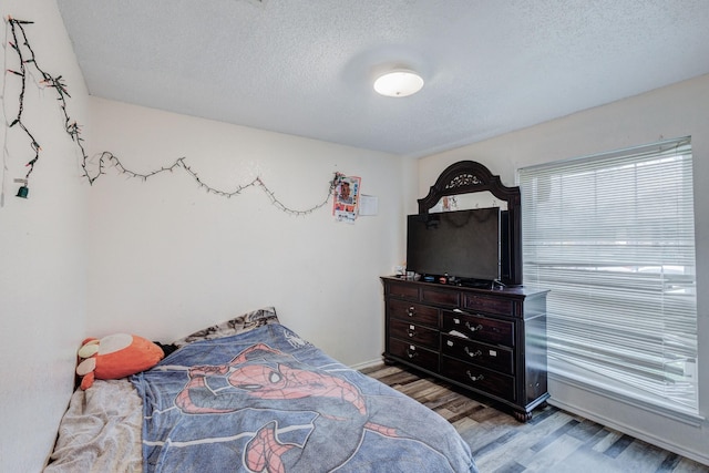 bedroom featuring wood-type flooring and a textured ceiling