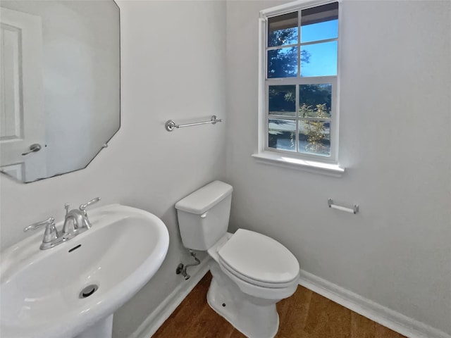 bathroom with hardwood / wood-style flooring, toilet, a healthy amount of sunlight, and sink