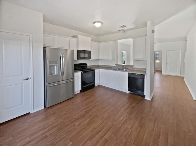 kitchen featuring black appliances, dark hardwood / wood-style flooring, white cabinets, and sink