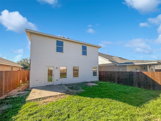 rear view of property featuring a lawn and a patio