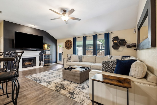 living room featuring ceiling fan, wood-type flooring, and lofted ceiling