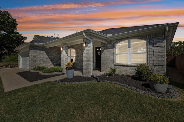 view of front of property with a garage and a yard