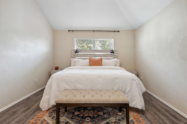 bedroom with dark wood-type flooring and lofted ceiling