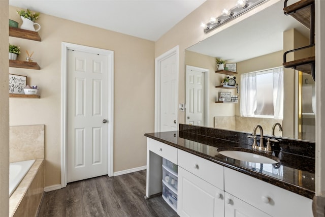 bathroom with vanity, hardwood / wood-style flooring, and a relaxing tiled tub