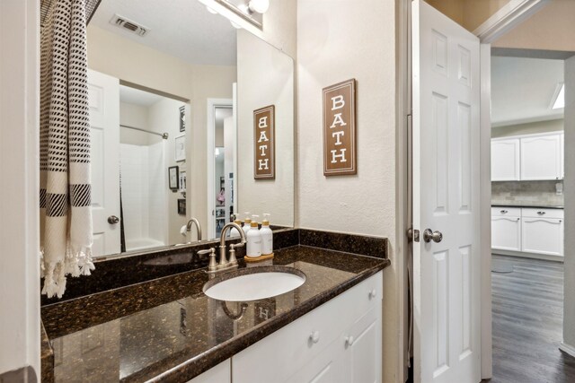 bathroom with hardwood / wood-style flooring, vanity, and shower / bath combination