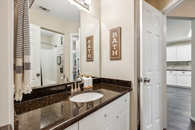 bathroom with shower / bath combination, vanity, wood-type flooring, and backsplash