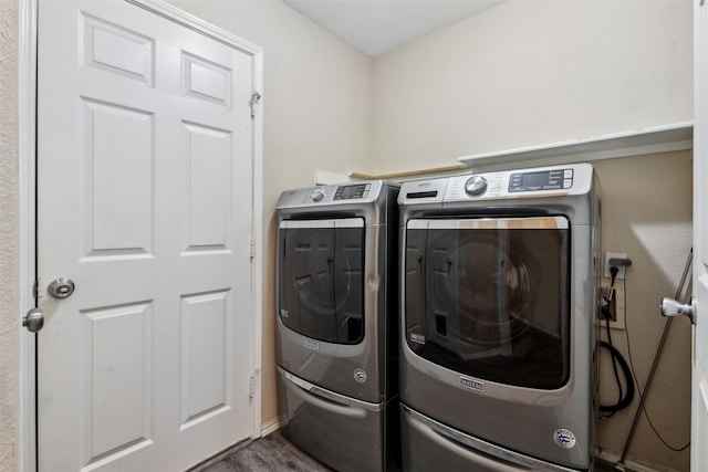 clothes washing area with washing machine and dryer and hardwood / wood-style floors