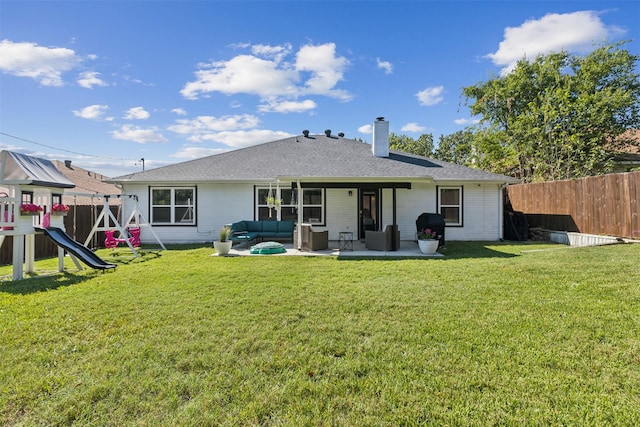 rear view of property with a yard, an outdoor hangout area, a playground, and a patio area