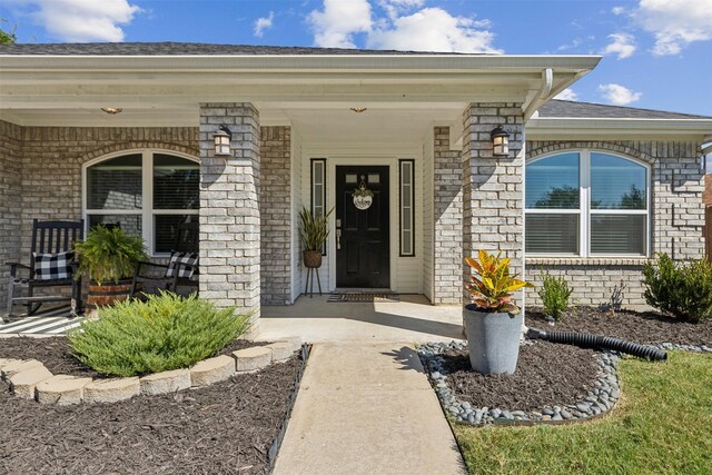 view of exterior entry featuring covered porch