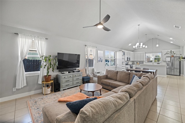 living room featuring ceiling fan with notable chandelier, light tile patterned floors, and lofted ceiling