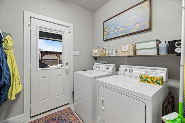 laundry area featuring light tile patterned floors and washing machine and dryer