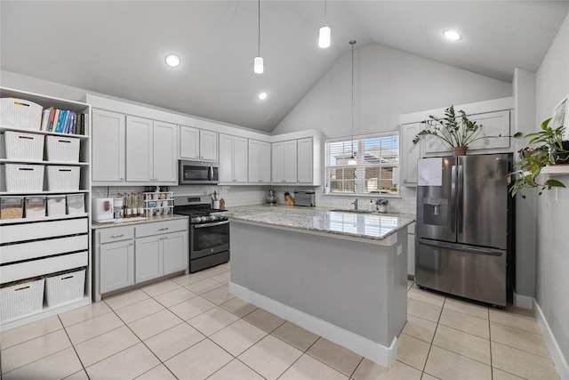 kitchen with light stone countertops, sink, hanging light fixtures, stainless steel appliances, and white cabinets